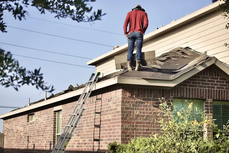 Professional roofer working on a residential roof in West Bay Shore